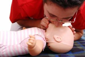 Practising CPR on a baby resuscitation manikin