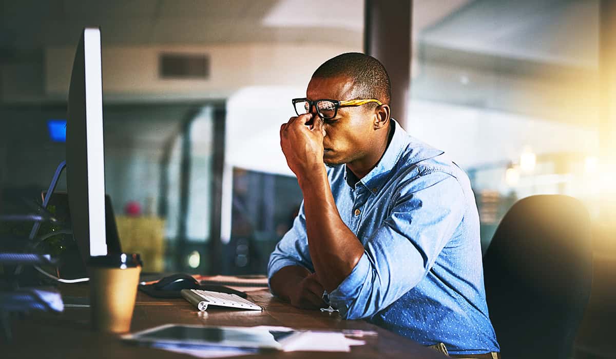An image of someone stressed in front of the computer