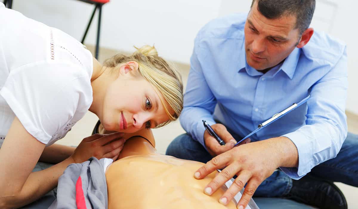 A woman performing the practical element of CPR training
